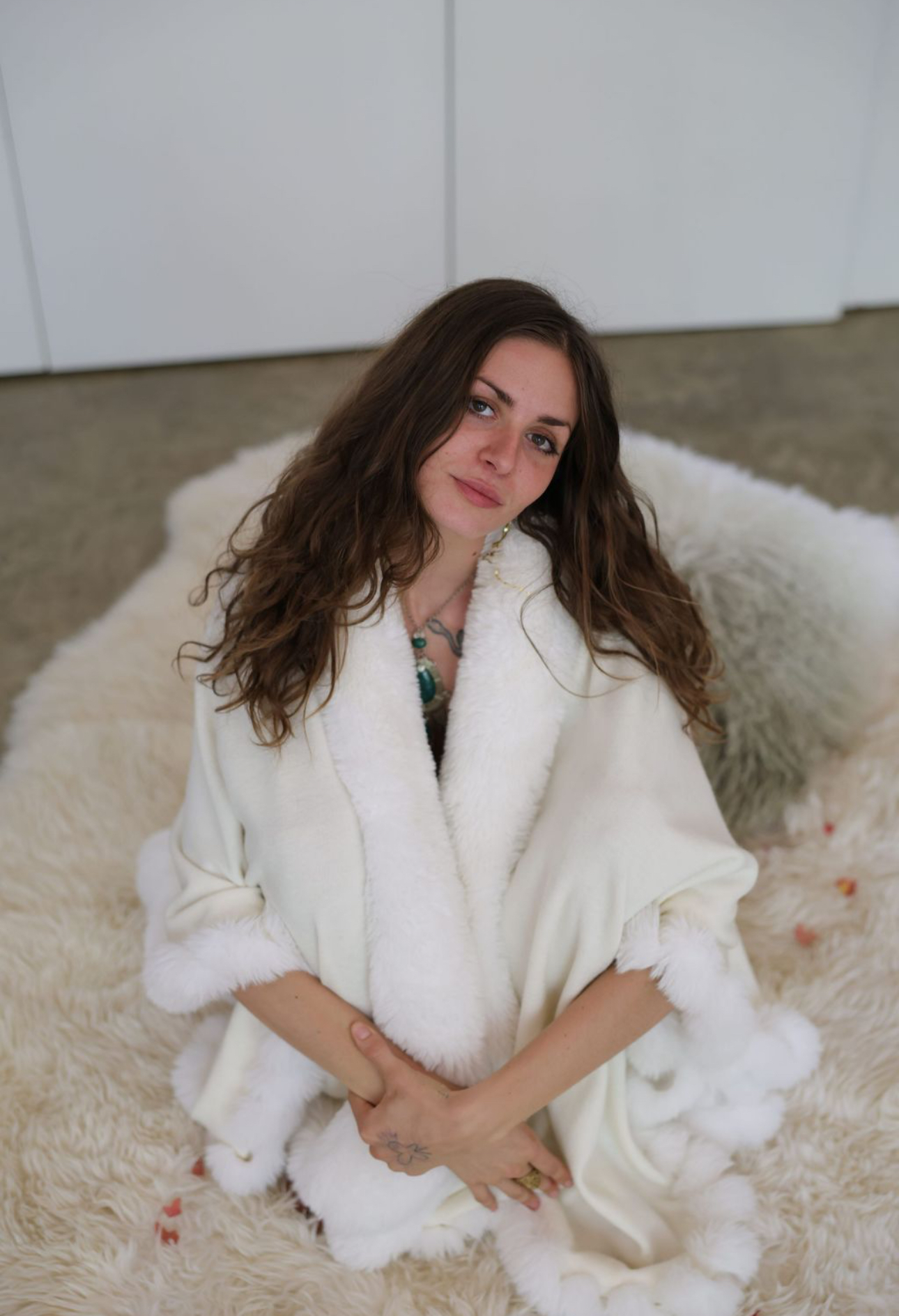 Your guide wrapped in a soft white coat, seated on a sheepskin rug